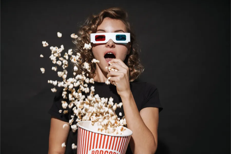 ポップコーンを食べながら3D映画を鑑賞している女性