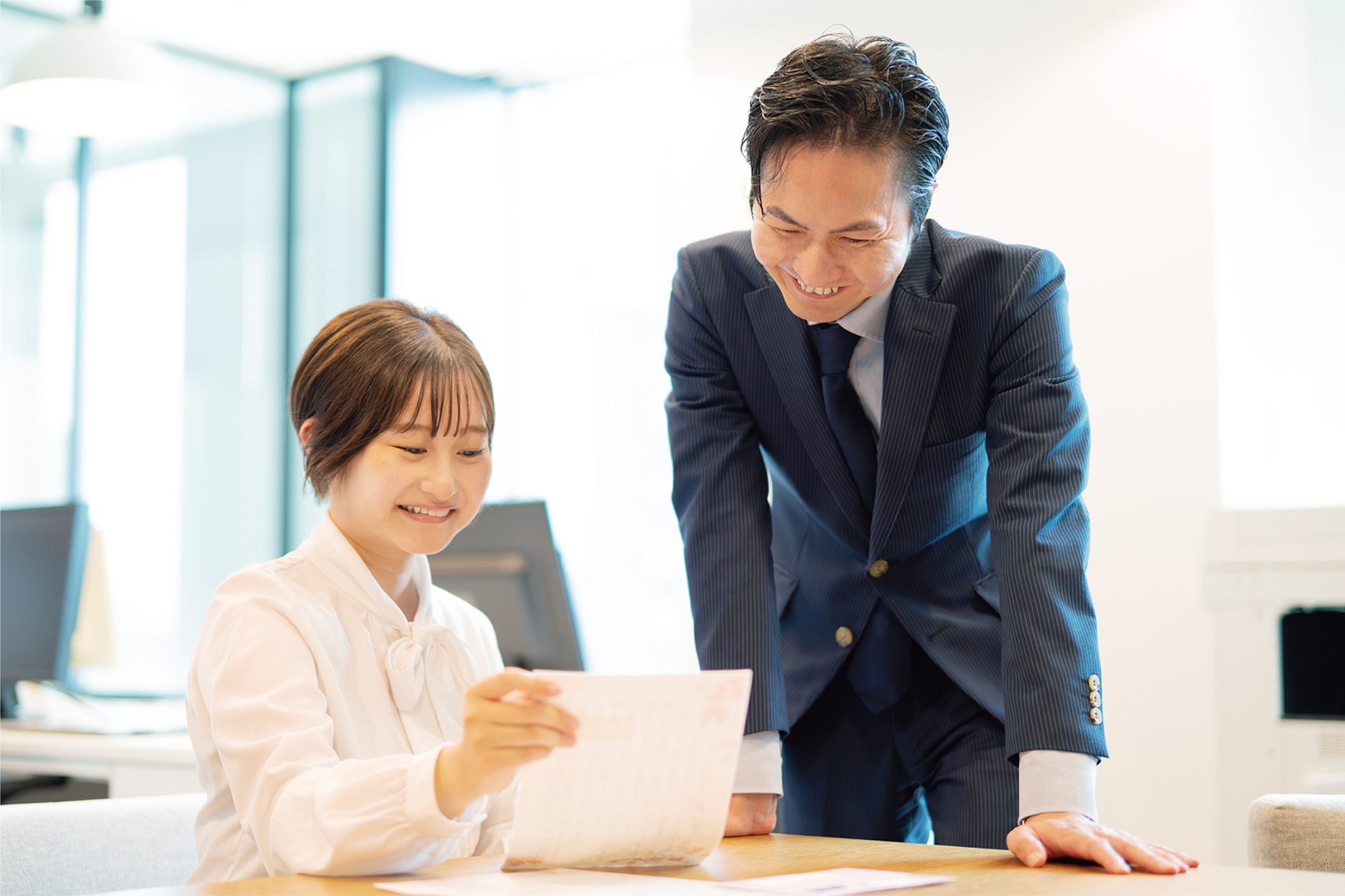 お客様アンケートを読んでいる男女のスタッフ