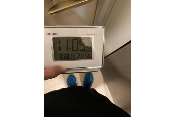 ランニングシューズを履いた自分の足を見下ろしている写真